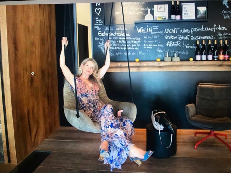 Interior Designerin Susanne Wefers auf einer Designschaukel im Showroom