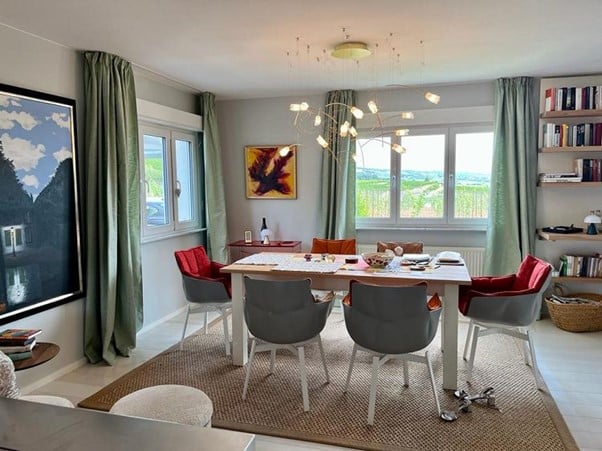 Elegantes Esszimmer mit rundem Esstisch, Designstühlen und Kunst in einer Wiesbadener Altbauwohnung
