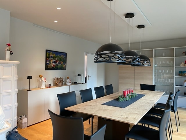 Moderner Esstisch mit Designleuchten in offener Wohnküche