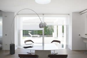 Lichtdurchflutetes Besprechungszimmer von WDW Interior Design mit ovalem Konferenztisch, Bogenleuchte und großen Fensterfronten mit Blick ins Grüne