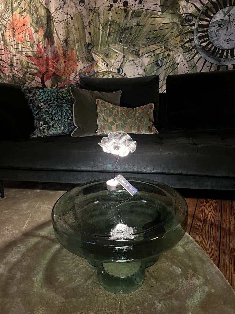 Wohnzimmer-Detail mit Glasschale und Kunstobjekt auf einem Glastisch